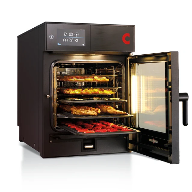 Commercial electric combi oven with touchscreen controls, open door and multiple trays of cooked food.