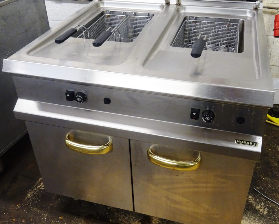 Electric commercial fryer featuring twin fry tanks, temperature control knobs, and undercounter storage doors.