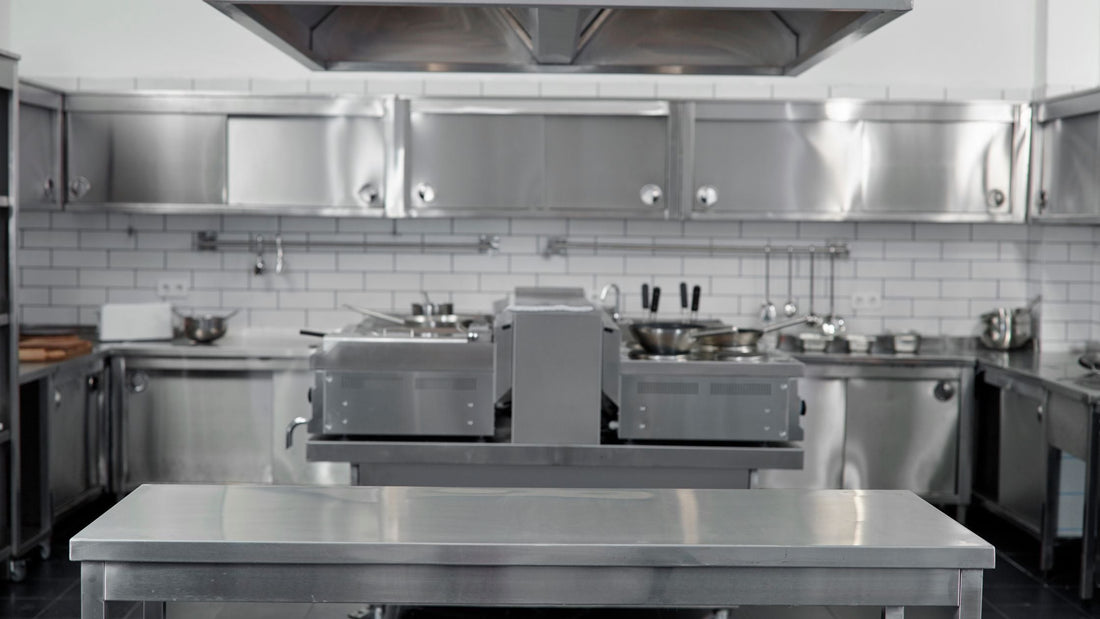 Empty professional kitchen with stainless steel appliances and workstations, representing stainless steel commercial kitchen equipment.