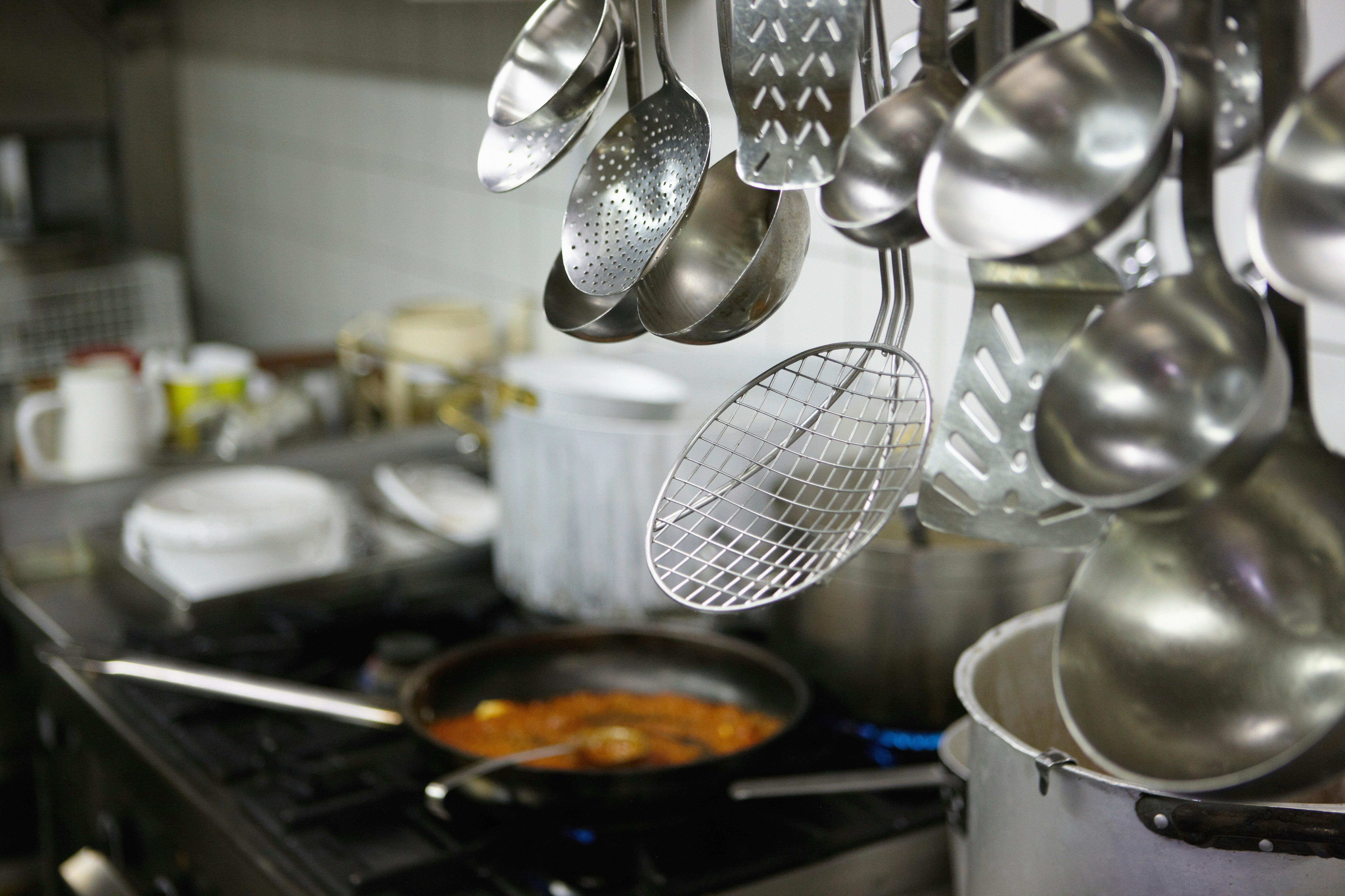Commercial cooking equipment and kitchen utensils in a professional restaurant kitchen designed for high-volume food preparation.