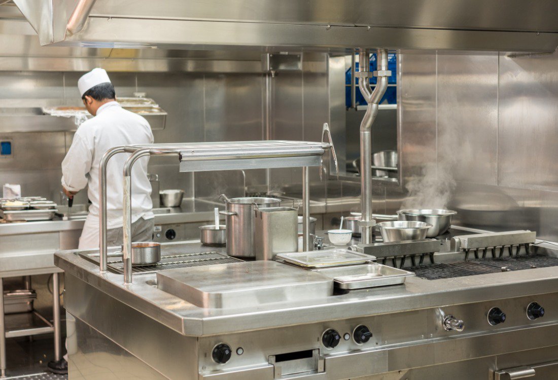 A chef working with energy-efficient commercial kitchen equipment to make the school more sustainable.