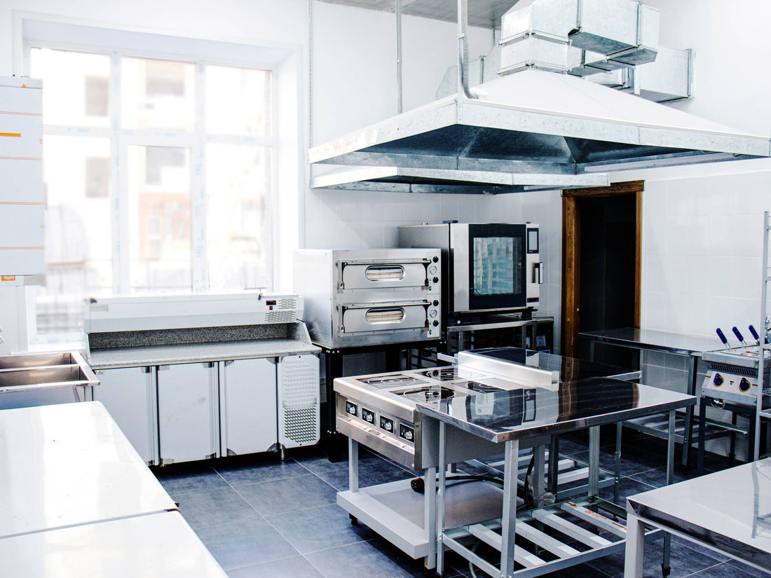 Modern commercial kitchen with stainless steel cooking stations, representing essential equipment in a commercial kitchen for restaurants.