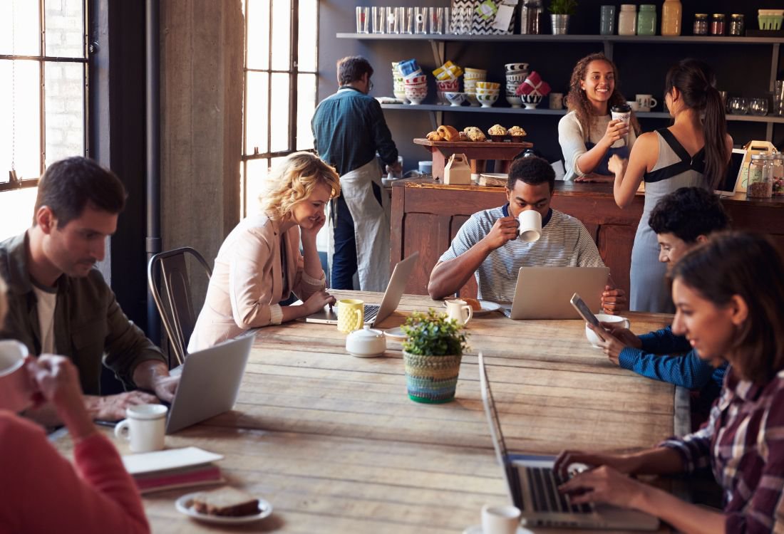 A woman serving smoothies in a coffee shop after looking at the best blenders for coffee shops.
